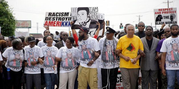 Michael Brown Sr., center, leads a march in remembrance of his son, Michael Brown, Sunday, Aug. 9, 2015, in Ferguson, Mo. Sunday marks one year since Michael Brown was shot and killed by Ferguson police officer Darren Wilson. (AP Photo/Jeff Roberson)