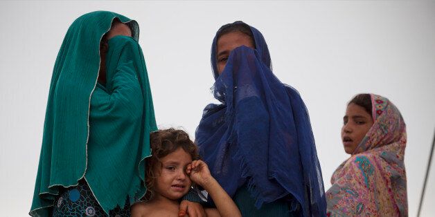 Pakistani displaced children cry as their houses are demolished by authorities in Islamabad, Pakistan, Thursday, July 30, 2015. Authorities demolished illegal mud houses of Afghan refugees and Pakistani tribal people who fled their villages due to ongoing crackdown operations against militants. Scores of people were injured during clashes between police and residents. (AP Photo/B.K. Bangash)