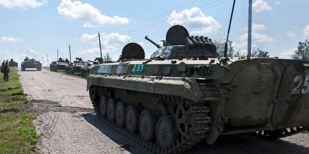 APCs with Russia-backed separatists are parked on a road at the site of the crashed Malaysia Airlines Flight 17 plane, near the village of Hrabove, eastern Ukraine, Thursday, July 16, 2015. The fighters said they have arrived to protect the media and make sure the MH17 crash site is clear of ammunition and mines. A year since a Malaysia Airlines Boeing 777 was blown out of the sky over war-ravaged eastern Ukraine, killing 298 people, there has been little official word of progress in determining what brought down Flight MH17. (AP Photo/Antoine E.R. Delaunay)