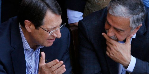 Cyprus President Nicos Anastasiades, left, and Turkish Cypriot leader Mustafa Akinci, speak as they sit at a coffee shop at the Turkish Cypriot breakaway northern part of the Cypriot divided capital Nicosia on Saturday, May 23, 2015. Cyprusâ rival Greek and Turkish Cypriot leaders took a stroll together on both sides of the divided capitalâs medieval center to raise the feel-good factor as talks aimed at reunifying the ethnically split island kick into gear. Itâs the first time th