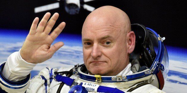 US astronaut Scott Kelly waves as his space suit is tested at the Russian-leased Baikonur cosmodrome, prior to blasting off to the International Space Station (ISS), late on March 27, 2015. The international crew of US astronaut Scott Kelly and Russian cosmonauts Gennady Padalka and Mikhail Kornienko is scheduled to blast off to the ISS from Baikonur early on March 28. AFP PHOTO / KIRILL KUDRYAVTSEV (Photo credit should read KIRILL KUDRYAVTSEV/AFP/Getty Images)