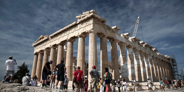 Tourists visit the ancient ruins of the Parthenon temple on Acropolis hill in Athens, Greece, on Thursday, June 4, 2015. Greek Prime Minister Alexis Tsipras will convene his inner circle to plot the next move in the standoff with international creditors after a round of top-level talks failed to yield a breakthrough. Photographer: Yorgos Karahalis/Bloomberg via Getty Images
