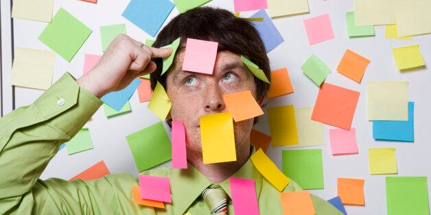 Male office worker covered with sticky notes