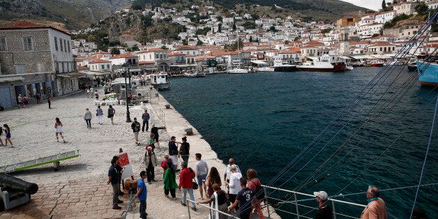 Tourists disembark from a cruise ship after travelling from Athens on the island of Hydra, Greece, on Monday, May 11, 2015. Less than three weeks after a Greek aid meeting broke up in taunts and acrimony, Finance Minister Yanis Varoufakis assured euro-area governments that his country is aiming to strike a bargain to win the final installments of its 240 billion-euro ($268 billion) aid program. Photographer: Yorgos Karahalis/Bloomberg via Getty Images