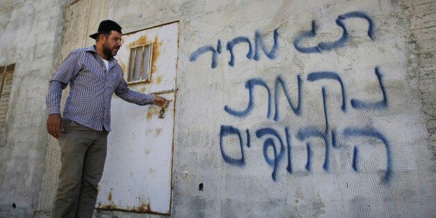 Φωτογραφία αρχείου. Παλαιστίνιος στέκεται έξω από σπίτι όπου η ισραηλινή εξτρεμιστική οργάνωση «price tag» έχει αφήσει το σημάδι της έπειτα από εμπρηστική επίθεση τον Ιούλιο του 2014