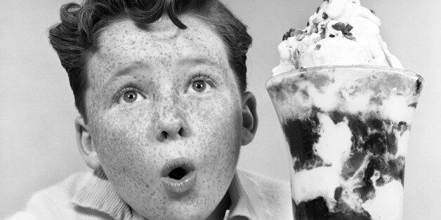 1950s FRECKLE FACED BOY WITH FUNNY EXPRESSION LOOKING AT GIANT SIZED ICE CREAM SUNDAE PARFAIT (Photo by H. Armstrong Roberts/ClassicStock/Getty Images)
