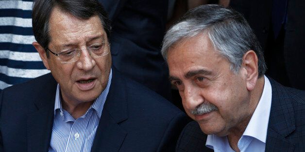 Cyprus President Nicos Anastasiades, left, and Turkish Cypriot leader Mustafa Akinci, speak as they sit at a coffee shop at the Turkish Cypriot breakaway northern part of the Cypriot divided capital Nicosia on Saturday, May 23, 2015. Cyprusâ rival Greek and Turkish Cypriot leaders took a stroll together on both sides of the divided capitalâs medieval center to raise the feel-good factor as talks aimed at reunifying the ethnically split island kick into gear. Itâs the first time th