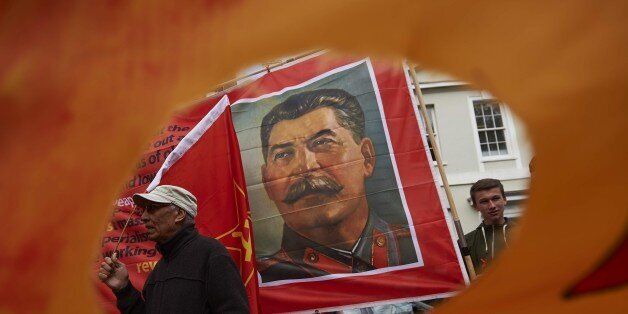 A portrait of Soviet Union leader Joseph Stalin is seen through a protesters flag in central London, on May 1, 2015, during the annual May Day rally. Hundreds rallied peacefully in Trafalgar square for the annual May Day anti-capitalist march and rally. AFP PHOTO / NIKLAS HALLE'N (Photo credit should read NIKLAS HALLE'N/AFP/Getty Images)