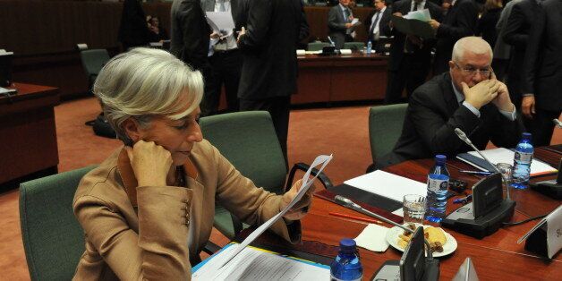 French Finance Minister Christine Lagarde (L) reviews notes while her Portuguese counterpart Fernando Teixeira dos Santos (R) phones before an extraordinary EU Economy and Finance Council meeting on May 9, 2010 at EU headquarters in Brussels. Sources said that ministers were examining a series of elements as part of plans to establish common bailout funds for troubled members hit by a debt crisis triggered in Greece, but which has since spread to other countries. AFP PHOTO / GEORGES GOBET (Phot