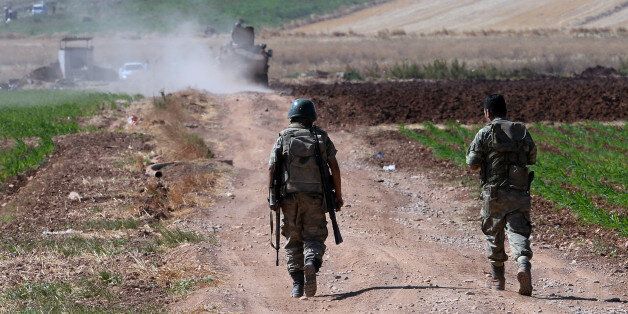 Turkish soldiers patrol near the border with Syria, ouside the village of Elbeyli, east of the town of Kilis, southeastern Turkey, Friday, July 24, 2015. Turkish warplanes struck Islamic State group targets across the border in Syria early Friday, government officials said, a day after IS militants fired at a Turkish military outpost, killing a soldier. The bombing is a strong tactical shift for Turkey which had long been reluctant to join the U.S.-led coalition against the extremist group. (AP Photo)
