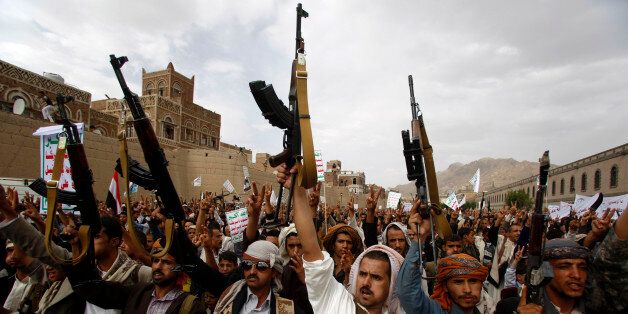 Shiite rebels known as Houthis hold up their weapons as they chant slogans during a rally against Saudi-led airstrikes in Sanaa, Yemen, Friday, July 24, 2015. (AP Photo/Hani Mohammed)