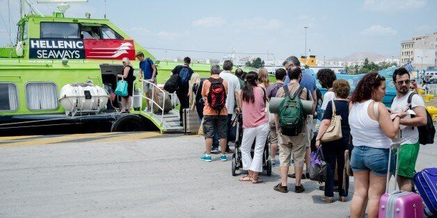 Tourists board a hydrofoil to go to the Greek islands in the Athens port of Piraeus on July 11, 2015. Last-minute tourist reservations for Greece have plunged by nearly a third since early last week as uncertainty piles up around the eurozone country, the Greek Tourism Confederation said on July 8. The country, known for its sun-bleached islands scattered in transparent waters, is financially stretched after years of austerity. AFP PHOTO / ANDREAS SOLARO (Photo credit should read ANDREAS SOLARO/AFP/Getty Images)