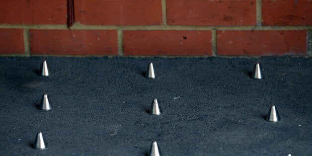 A picture shows short metal spikes installed outside the entrance of a building in London on June 10, 2014. The installation of pavement spikes to stop homeless people sleeping outside a London building sparked outrage on June 10, with 40,000 people signing a petition in protest and Mayor Boris Johnson calling them 'stupid'. AFP PHOTO / CARL COURT (Photo credit should read CARL COURT/AFP/Getty Images)