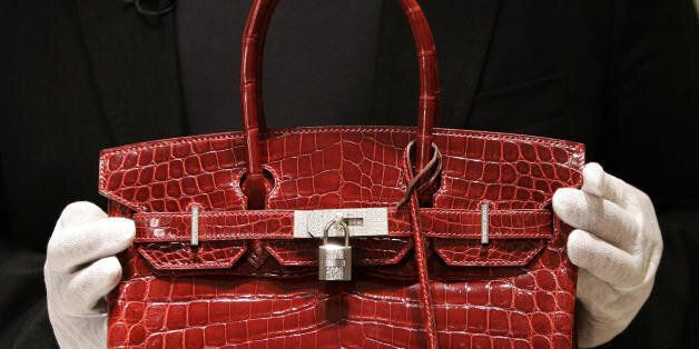New York, UNITED STATES: A employee holds a 129,000 USD crocodile Hermes Birkin Bag for the press to see during a private opening for the new Hermes store on Wall Street in New York 21 June 2007. The store which is located at 15 Broad Steet is across the street from the New York Stock Exchange. The store is one of several luxury shops opening near Ground Zero as part of a revitalization project in the area. AFP PHOTO/ TIMOTHY A. CLARY (Photo credit should read TIMOTHY A. CLARY/AFP/Getty Images)