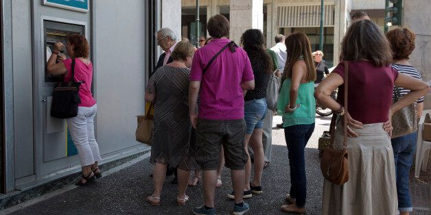 People line up at an ATM outside a National bank branch, in central Athens, on Monday, June 29, 2015. Anxious Greeks lined up at ATMs as they gradually began dispensing cash again on the first day of capital controls imposed in a dramatic twist in Greeceâs five-year financial saga. Banks will remain shut until next Monday, and a daily limit of 60 euros ($67) has been placed on cash withdrawals from ATMs. (AP Photo/Petros Giannakouris)