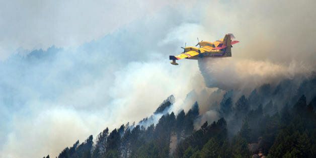 A Canadair works to extinguish fire on la Vacca mount, near the village of Aullene, Corsica, on July 25, 2009. Three fires started on July 23, 2009 in Corsica burning 5 to 6.000 hectares of forest. Deadly summer wild fires spread across Spain, France, Italy and Greece with holidaymakers rescued from beaches and thousands of firefighters brought into the battle. AFP PHOTO STEPHAN AGOSTINI (Photo credit should read STEPHAN AGOSTINI/AFP/Getty Images)