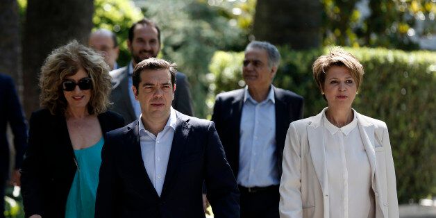 Greece's Prime Minister Alexis Tsipras, center, leaves from the Presidential Palace with the new members of his government after a swearing in ceremony in Athens, Saturday, July 18, 2015. Tsipras reshuffled his Cabinet on Friday following a rebellion within his party over a parliamentary vote to approve the measures demanded for the bailout talks to start. Greek parliament approved creditor's demand for austerity measures. (AP Photo/Thanassis Stavrakis)