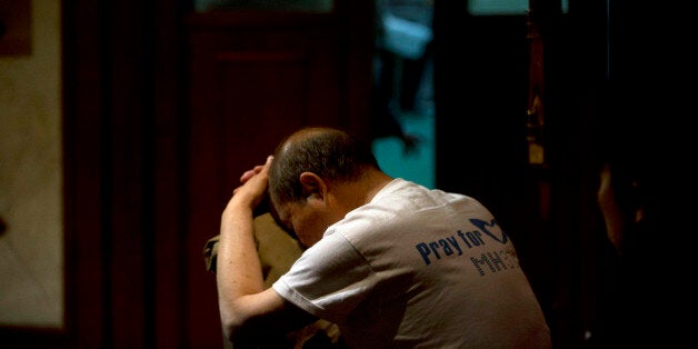 A relative of Chinese passengers on board the Malaysia Airlines Flight MH370 rests on a chair as he waits for news in Beijing, China, Friday, April 4, 2014. Two ships with sophisticated equipment for searching underwater zeroed in Friday on a remote stretch of the Indian Ocean in a desperate hunt for the missing Malaysia Airlines jet's black boxes, whose batteries will soon run out. (AP Photo/Ng Han Guan)