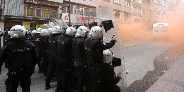 Turkish riot police officers hold their positions during clashes with demonstrators in Istanbul, Turkey, Friday, May 1, 2015. Clashes erupted between police and May Day demonstrators in Istanbul on Friday as crowds determined to defy a government ban tried to march to the city's iconic Taksim Square. Security forces pushed back demonstrators with a water cannon and tear gas. (AP Photo/Emrah Gurel)