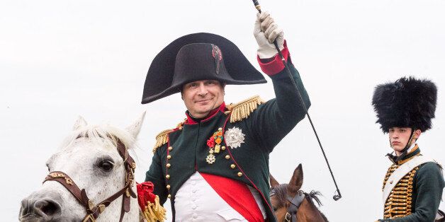 A re-enactor playing the role of the Napoleon Bonaparte rides his horse during the reconstruction of
