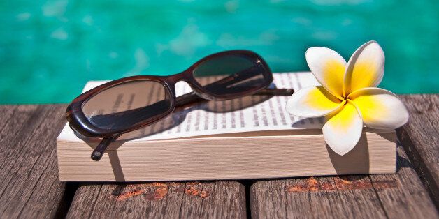 Book and sunglasses, blue water, background