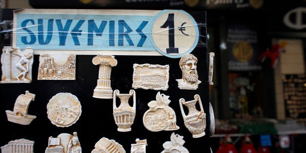 A one euro price sign sits on a display of souvenir fridge magnets for sale to tourists outside a euro store in Athens, Greece, on Thursday, Jan. 8, 2015. Greek Prime Minister Antonis Samaras's effort to overhaul opposition Syriza party's lead before elections in less than three weeks is running out of steam, polls show. Photographer: Kostas Tsironis/Bloomberg via Getty Images