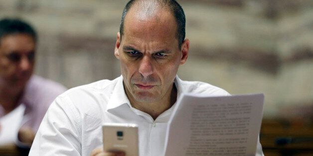 Parliament member Yanis Varoufakis checks his cell phone before a meeting with lawmakers of Syriza party at the Greek Parliament in Athens, Friday, July 10, 2015. Greece's Prime Minister Alexis Tsipras will seek backing for a harsh new austerity package from his party Friday to keep his country in the euro â less than a week after urging Greeks to reject milder cuts in a referendum. (AP Photo/Thanassis Stavrakis)