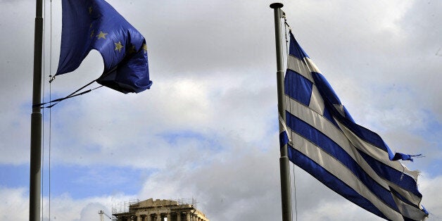 Ripped EU and Greek flags flutter in Athens on February 9, 2012. The debt rescue for Greece hits an 11th-hour hurdle on pension cuts, with eurozone ministers poised to meet on a package to avert default and Greek unions calling another general strike to fight the terms. AFP PHOTO/ LOUISA GOULIAMAKI (Photo credit should read LOUISA GOULIAMAKI/AFP/Getty Images)