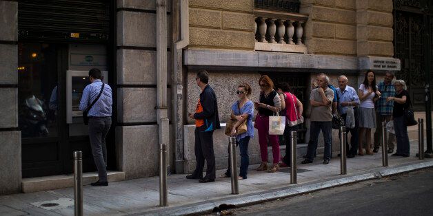 People line up to withdraw money from a bank machine in central Athens, Friday, July 3, 2015. As Greek banks and markets remain closed Friday for a fifth day, rival campaigns scrambled to roll out their messages. And a prediction from the International Monetary Fund that Greece will need piles of additional cash from eurozone countries and others over the next three years put even more pressure on the government. (AP Photo/Emilio Morenatti)