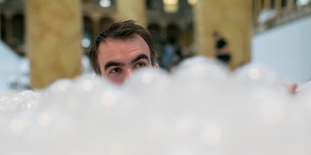 UNITED STATES - JULY 1 - Alex Mustonen, Co-founder of Snarkitecture, is seen head deep in The Beach,' an interactive architectural installation that features a 10,000 feet 'ocean' of nearly one million recyclable plastic balls during a media tour at the National Building Museum in Washington on Thursday, June 2, 2015. (Photo By Al Drago/CQ Roll Call)