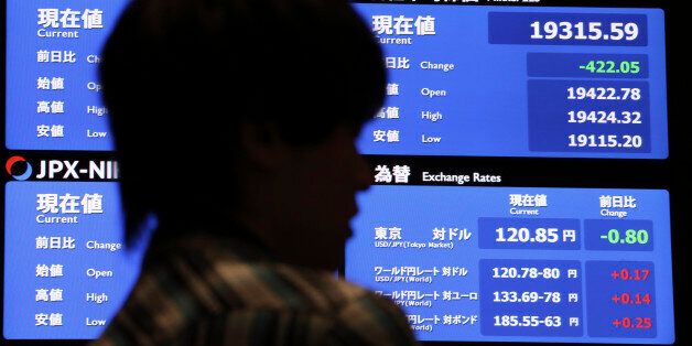 A local media reports the day's loss of Japan's Nikkei stock index in front of an electronic board at Tokyo Stock Exchange in Tokyo Thursday, July 9, 2015. Asian stocks markets were volatile on Thursday as China's main index seesawed after a prolonged sell-off while Hong Kong's benchmark rebounded strongly. (AP Photo/ Eugene Hoshiko)