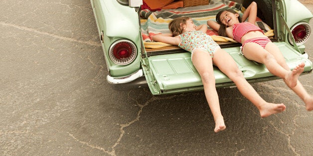 Two girls lying in estate car