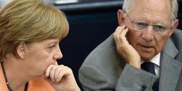 German Finance Minister Wolfgang Schaeuble (R) and German Chancellor Angela Merkel chat during a session at the Bundestag lower house of parliament on the Greek crisis on July 1, 2015 in Berlin. German Chancellor Angela Merkel said that 'the future of Europe is not at stake' because of the crisis over Greece after the breakdown of debt talks and expiry of its aid programme. AFP PHOTO / ODD ANDERSEN (Photo credit should read ODD ANDERSEN/AFP/Getty Images)