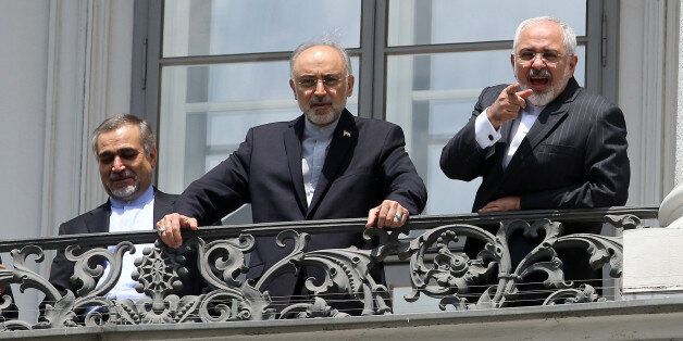 Hossein Fereydoon, brother and close aide to President Hassan Rouhani, Head of the Iranian Atomic Energy Organization Ali Akbar Salehi and Iranian Foreign Minister Mohamad Javad Zarif, from left, speak with journalist from a balcony of the Palais Coburg where closed-door nuclear talks with Iran take place in Vienna, Austria, Friday, July 10, 2015. (AP Photo/Ronald Zak)