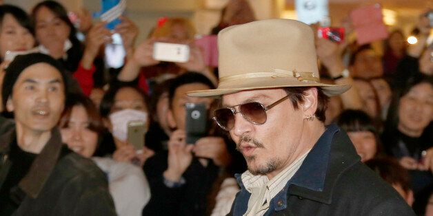 U.S. actor Johnny Depp waves to his fans upon arriving at Haneda international airport in Tokyo Monday, Jan. 26, 2015 for his latest film