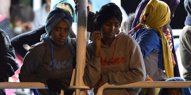 Migrants wait to disembark from the Migrant Offshore Aid Station (MOAS) ship Phoenix in the Sicilian port town of Augusta, Italy, Sunday, June 7, 2015. Heartened by recent election successes by an anti-immigrant party, Italian politicians based in the north vowed Sunday not to shelter any more migrants saved at sea, even as thousands more were being rescued in the Mediterranean from smugglers' boats in distress. (AP Photo/Carmelo Imbesi)