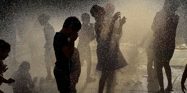 Children cool off under water fountain, in Pamplona northern Spain, Tuesday, June 30, 2015. A mass of hot air moving north from Africa is bringing a heat wave to Europe, with France the next in line for a scorching day. Forecasters said southern France could see temperatures over 40 degrees Celsius on Tuesday, a day after Cordoba in southern Spain recorded 43.7 degrees Celsius (110.66 Fahrenheit). Spain and Portugal issued weather alerts on Monday, advising residents to take extra care, as the heat plume passed through the Iberian peninsula. (AP Photo/Alvaro Barrientos)