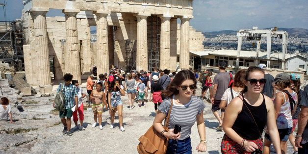 ATHENS, GREECE - JUNE 30: Tourists visit the ancient Acropolis hill, with the ruins of the fifth century BC Parthenon temple on June 30, 2015 in Athens, Greece. Greek voters will decide in a referendum next Sunday on whether their government should accept an economic reform package put forth by Greece's creditors. Greece has imposed capital controls with the banks being closed until the referendum and a daily limit of 60 euros has been placed on cash withdrawals from ATMs. (Photo by Milos Bicanski/Getty Images)