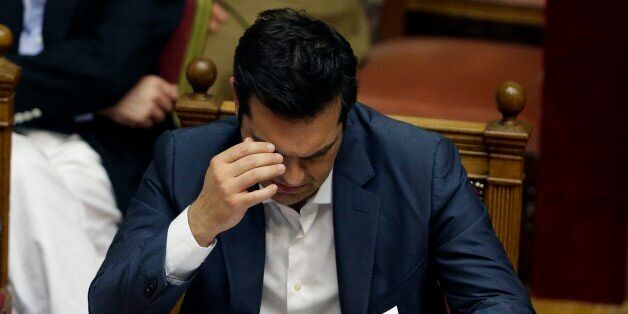 Greece's Prime Minister Alexis Tsipras reads his notes during a parliament meeting in Athens, Thursday, July 16, 2015. Tsipras was fighting to keep his government intact in the face of outrage over an austerity bill that parliament must pass if the country is to start negotiations on a new bailout and avoid financial collapse. (AP Photo/Thanassis Stavrakis)
