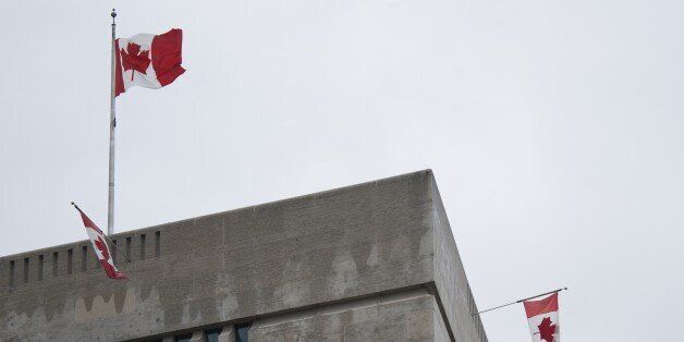 Flags fly over the Canadian Embassy in Washington, DC, October 22, 2014. Gunfire echoed through the Gothic halls of the Canadian parliament in Ottawa, Wednesday as police shot dead a gunman who had killed a soldier guarding a nearby war memorial before storming the building. Police said an investigation was continuing, but did not confirm earlier reports that more gunmen were involved. Heavily armed officers backed by armored vehicles sealed off the building.There was no immediate word on the gunman's motivation, but the attack came a day after an alleged Islamist drove over and killed another soldier in what authorities branded a terrorist attack. AFP PHOTO/JIM WATSON (Photo credit should read JIM WATSON/AFP/Getty Images)