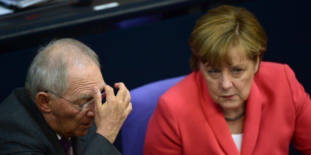 German Chancellor Angela Merkel (R) speaks with German Finance Minister Wolfgang Schaeuble before addressing the members of parliament on her positions ahead of an EU summit and on Greece rescue efforts at the Bundestag lower house of parliament in Berlin on June 18, 2015. Merkel said she was convinced it was still possible to reach an accord with Greece on its crippling debt crisis, ahead of crunch EU meeting on June 25. AFP PHOTO / JOHN MACDOUGALL (Photo credit should read JOHN MACDOUGALL/AFP/Getty Images)