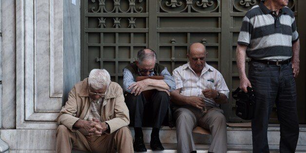 Pensioners wait outside a national bank brunch, as banks only opened for pensioners to allow them to get their pensions, with a limit of 120 euros, in Athens on July 2, 2015. Greece's left-wing government 'may very well' resign if a referendum this weekend on bailout conditions results in a 'Yes' vote, Finance Minister Yanis Varoufakis said in a radio interview Thursday. AFP PHOTO / ARIS MESSINIS (Photo credit should read ARIS MESSINIS/AFP/Getty Images)