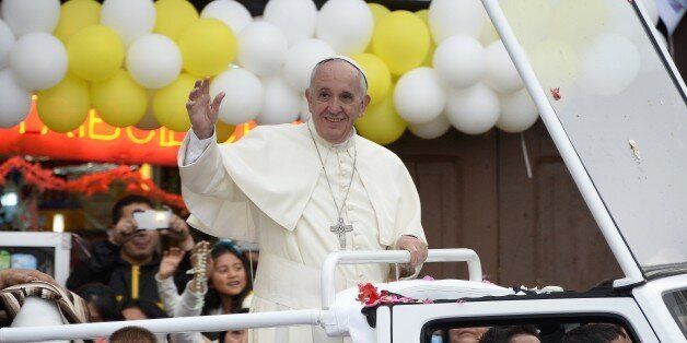 Pope Francis waves as he rides in the popemobile through the Ecuadorean capital, Quito, on July 7, 2015. Pope Francis addressed 900,000 faithful who braved the cold and rain to hear him at an outdoor mass in Quito's Bicentennial Park. 'Fight for inclusion at all levels,' the pontiff said, pleading for 'dialogue' on the third day of a South American tour that will also take him to Bolivia and Paraguay. AFP PHOTO / JUAN CEVALLOS (Photo credit should read JUAN CEVALLOS/AFP/Getty Images)