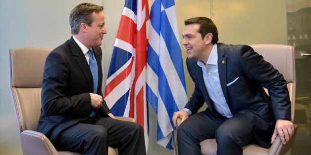 British Prime Minister David Cameron, left, speaks with Greek Prime Minister Alexis Tsipras during a meeting on the sidelines of an EU summit in Brussels on Thursday, Feb. 12, 2015. European Union leaders on Thursday said the full respect of the planned weekend cease-fire in eastern Ukraine will be essential before there could be a change in the sanctions regime imposed on Moscow. (AP Photo/Francois Lenoir, Pool)