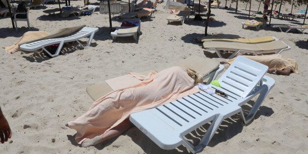 Bodies are covered on a Tunisian beach, in Sousse, Friday June 26, 2015. A young man unfurled an umbrella and pulled out a Kalashnikov, opening fire on European sunbathers in an attack that killed at least 28 people at a Tunisian beach resort â one of three deadly attacks from Europe to the Middle East on Friday that followed a call to violence by Islamic State extremists. (Jawhara FM via AP)