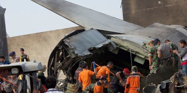 MEDAN, INDONESIA - JUNE 30: Military personnel and search and rescue teams comb through the wreckage of a military transport plane which crashed into a building on June 30, 2015 in Medan, Indonesia. Over 30 bodies have been recovered from the crash site in a residential neighbourhood after the military transport plane with 12 crew crashed shortly after taking off from a military airbase in Medan. (Photo by Ed Wray/Getty Images)