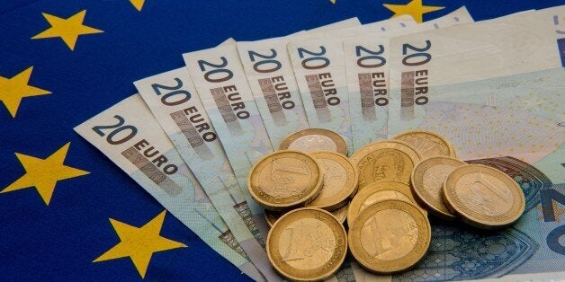 A picture taken on June 29, 2015 in Lille shows Drachma bills, Greece's former currency, next to euro bills and coins. The European single currency briefly dropped below $1.1 today as investors grow concerned Greece is headed for a debt default and a possible eurozone exit. AFP PHOTO / DENIS CHARLET (Photo credit should read DENIS CHARLET/AFP/Getty Images)