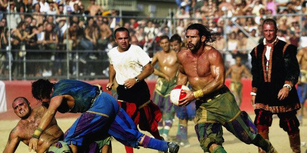 FLORENCE - JUNE 24: A Verdi player finds a gap in the Azzurri team's defence during the Calcio Storico, a medieval football rules event held between four quarters of Florence since 1584 on June 24, 2003 at La Piazza Santa Croce in Florence, Italy. (Photo by Michael Steele/Getty Images)
