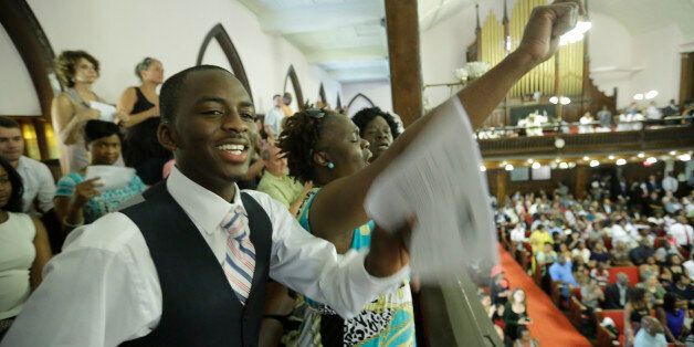 CHARLESTON, SC - JUNE 21: Parishioners Shakur Francis, left, and Karen Watson-Fleming sing as they attend the first church service four days after a mass shooting that claimed the lives of nine people at the historic Emanuel African Methodist Church June 21, 2015 in Charleston, South Carolina. Chruch elders decided to hold the regularly scheduled Sunday school and worship service as they continue to grieve the shooting death of nine of its members including its pastor earlier this week. (Photo