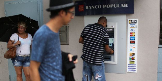 SAN JUAN, PUERTO RICO - JUNE 30: People use a Banco Popular ATM machine a day after Puerto Rican Governor Alejandro Garcia Padilla gave a televised speech regarding the governments $72 billion debt on June 30, 2015 in San Juan, Puerto Rico. The Governor said in his speech that the people will have to sacrifice and share in the responsibilities for pulling the island out of debt. (Photo by Joe Raedle/Getty Images)